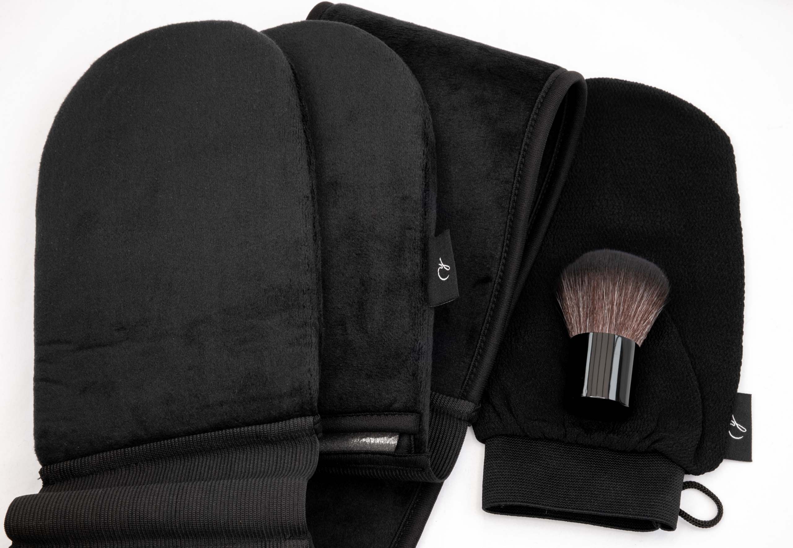 Overhead product photo showing a full set of black tanning mitts, an exfoliating glove, a tanning belt, and kabuki brush on a white background.